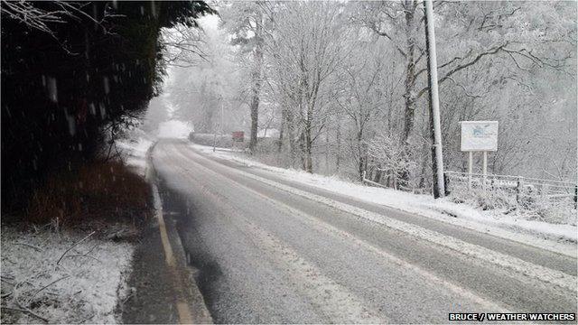 Snow falling on country road making it slippery