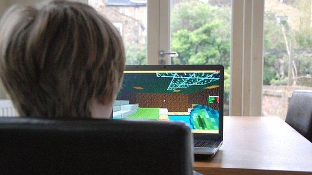 Boy plays Minecraft at kitchen table