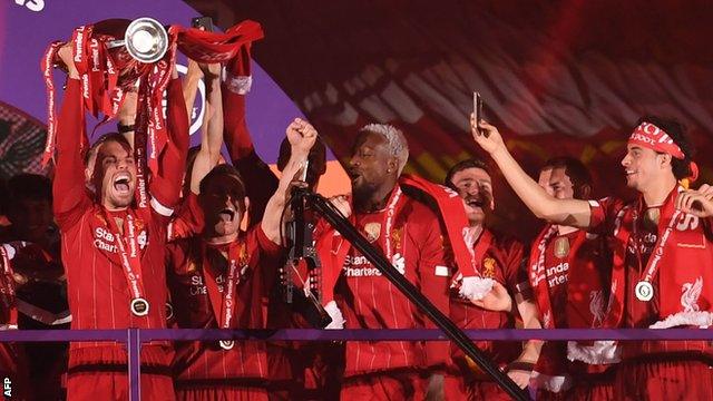 Liverpool's players celebrate as they lift the Premier League trophy