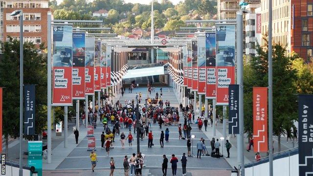 A small number of Arsenal fans celebrate on Wembley Way after the club secure a record 14th FA Cup triumph