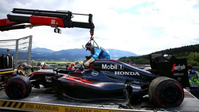 Fernando Alonso's McLaren is craned off