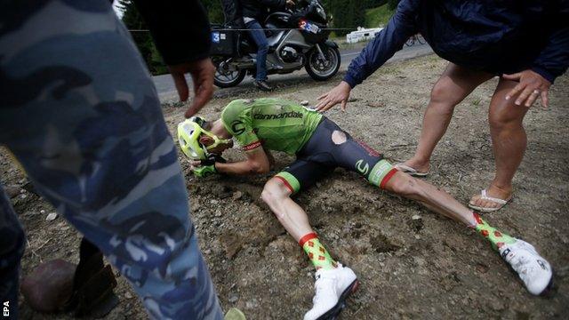 France's Pierre Rolland slips on the wet tarmac