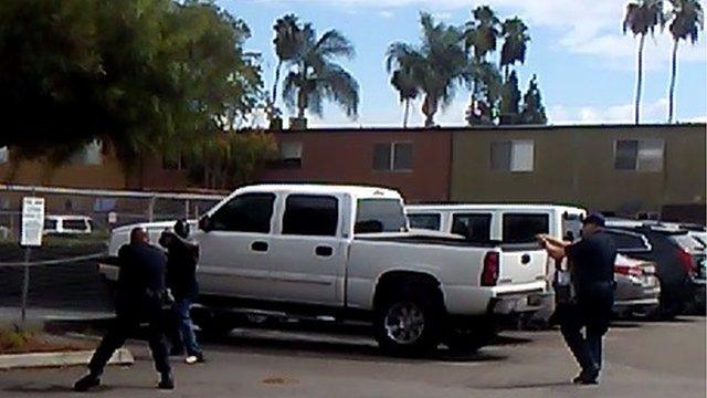 In this video grab courtesy of the El Cajon Police Department and obtained by AFP on September 28, 2016, a man raises his hands as members of the police department approach in El Cajon a suburb of San Diego, California.