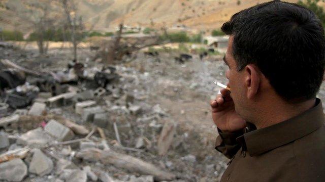 A man looks over at destroyed buildings