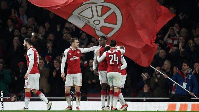 Arsenal players celebrate scoring against AC Milan