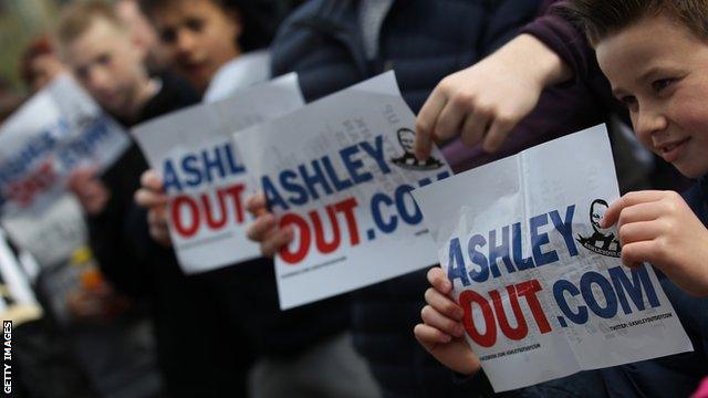 Newcastle United supporters with posters against owner Mike Ashley