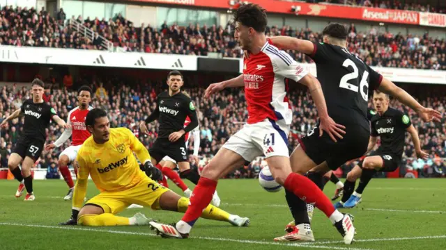 West Ham goalkeeper Alphonse Areola stops a shot by Declan Rice