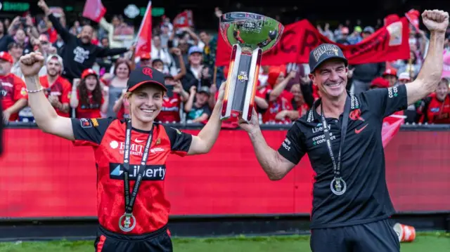 Captain Sophie Molineux and Head Coach Simon Helmot of Melbourne Renegades holding the winning trophy during Weber Women's Big Bash League
