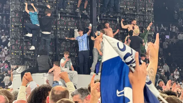 Fans celebrating in front of screen at Tottenham stadium