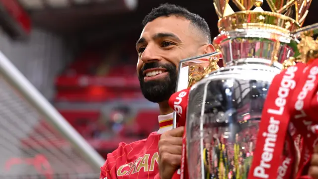 Mohamed Salah holds the Premier League trophy