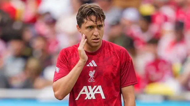 Federico Chiesa stands on the pitch with his hand on his face