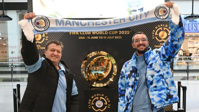 Two Manchester City fans pose with the Club World Cup