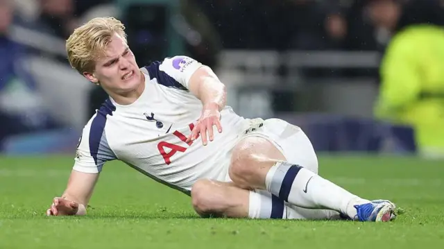 Lucas Bergvall on the turf in pain. He has a grimace on his face.