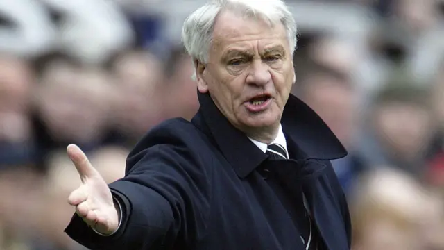 Sir Bobby Robson stands on the touchline