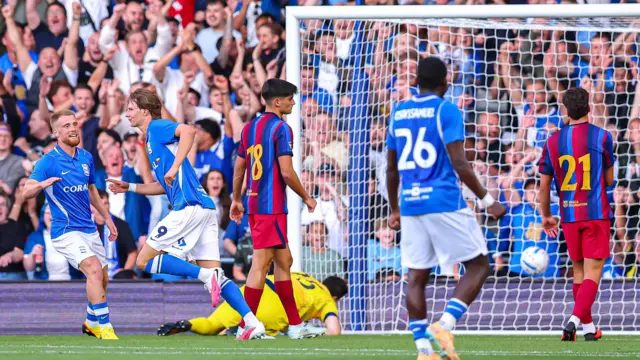 August Priske (second left), wearing Birmingham City blue and white home kit, celebrates after scoring in a pre-season friendly against Barcelona at St Andrew's. Birmingham fans can be seen celebrating behind the goal.