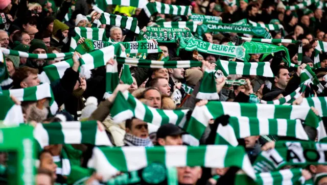 Celtic fans hold up green and white scarves during the Old Firm derby