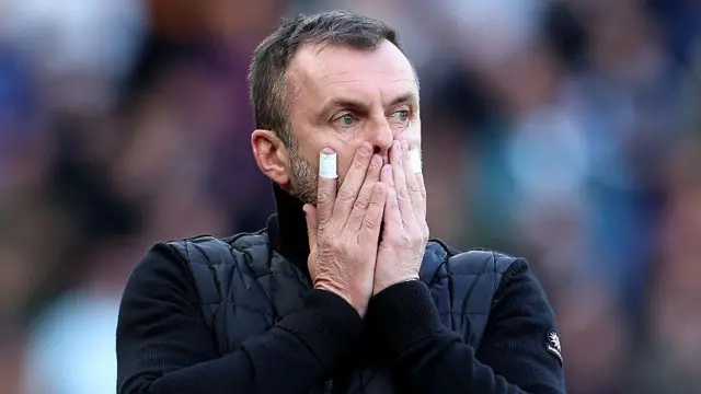 A photo of Charlton boss Nathan Jones with both his hands over his mouth