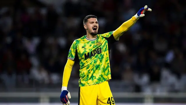 Arijanet Muric in a yellow Sassuolo goalkeeping kit shouts at his defenders during a game