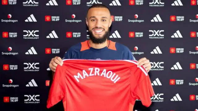 Noussair Mazraoui holds a Manchester United shirt with his name printed on the back