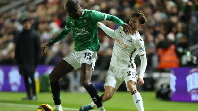 Mustapha Bundu challenges Liam Cullen during Swansea City's win at Plymouth earlier this season
