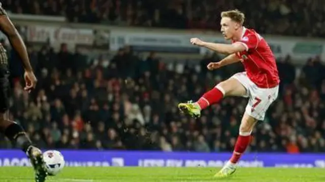 Keillor-Dunn takes a shot for Wrexham against Hull with his right foot wearing Wrexham's home kit with number seven on his shorts.