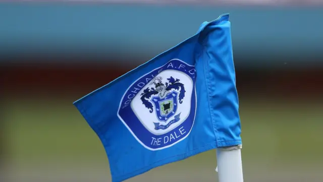 A blue corner flag with the Rochdale AFC badge on it 