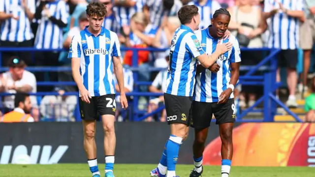 Sheffield Wednesday players, wearing the Owls blue and white striped home shirt, celebrate Jamal Lowe's goal in the EFL Cup against Bolton.