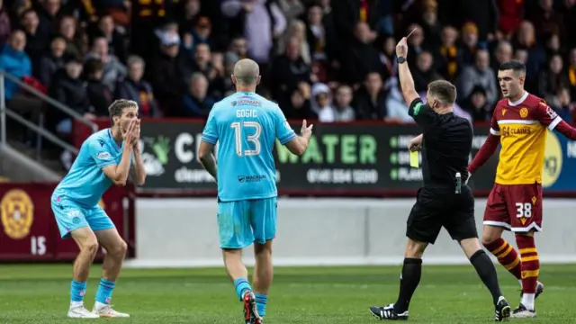 Scott Tanser is shown a second yellow card v Motherwell