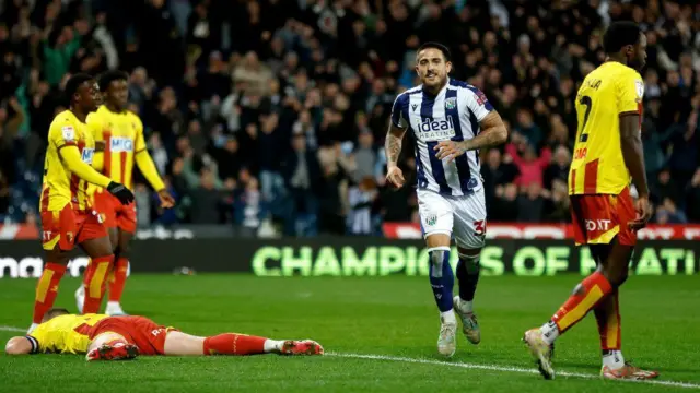 A West Brom player celebrates as Watford players look in dismay. 