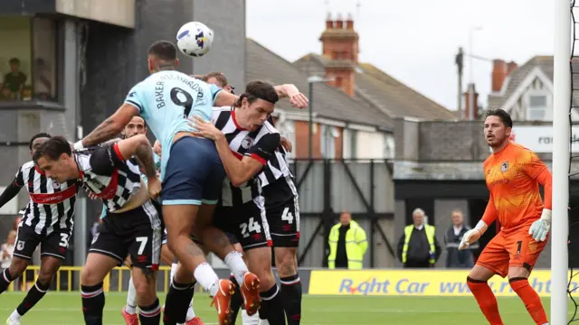 Newport County's Courtney Baker-Richardson is crowded out in the goalmouth at Grimsby