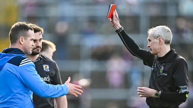 Fergal Kelly shows a red card to Ger Brennan and Cian Breathnach McGinn