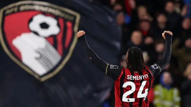 Back of Antoine Semenyo celebrating in front of Bournemouth flag
