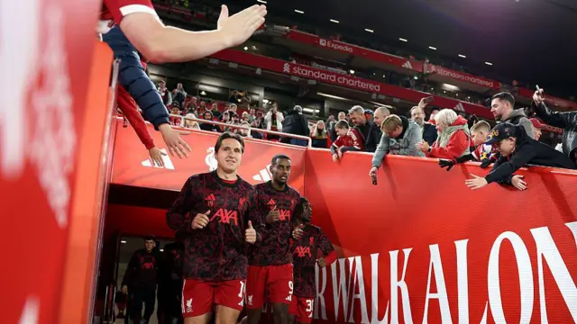 Federico Chiesa runs out of the tunnel at Anfield. Fans clap him and Alexander Isak out.