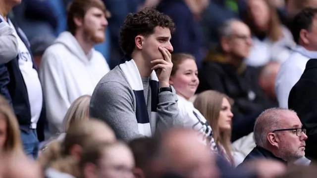 A Tottenham Hotspur fan looks dejected.
