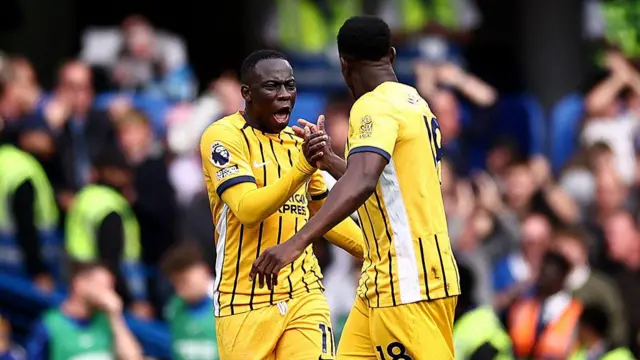 Brighton striker Danny Welbeck celebrates scoring the equalising goal alongside midfielder Yankuba Minteh