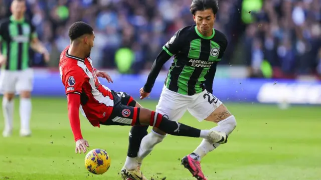 Sheffield United's Mason Holgate fouls Kaoru Mitoma