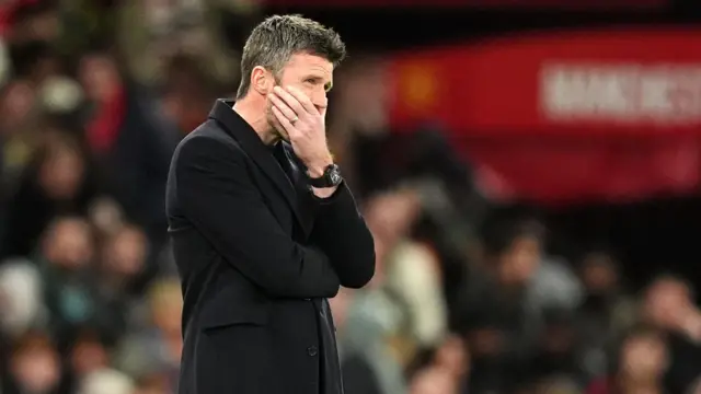 Michael Carrick stands with his hand on his face