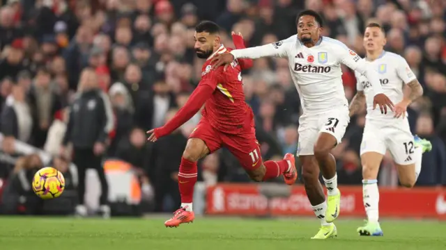 Leon Bailey chases Mohamed Salah for the ball