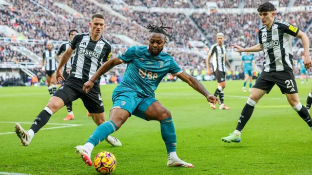 Antoine Semenyo shields the ball from Newcastle players 