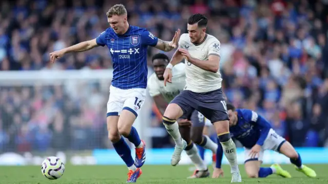 Jack Taylor and Jack Harrison contest for the ball