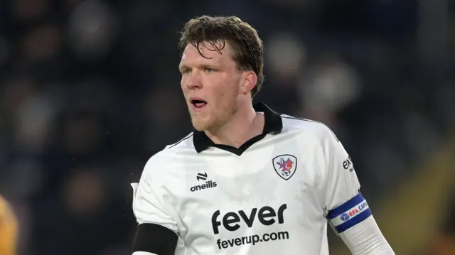 Rob Dickie standing on the pitch during a match looking to his right midway through talking