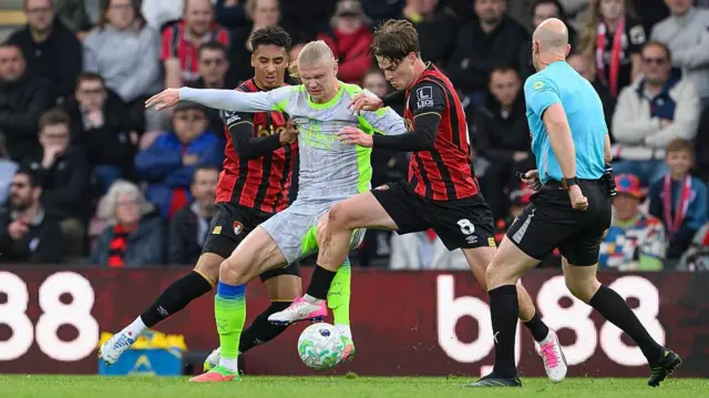 Bournemouth's James Hill (left) and Bournemouth's Alex Scott (right) battles with Manchester City's Erling Haaland