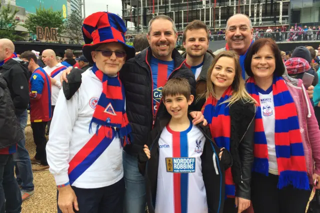 A group of adults and children dressed in Crystal Palace gear outside of Wembley