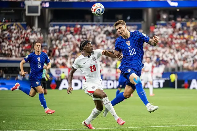 Luka Vuskovic heads the ball away under pressure from Noni Madueke during Croatia's game against England at the World Cup