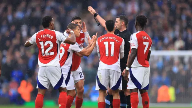 Leandro Trossard of Arsenal protests after being shown the red card by referee Michael Oliver during the Premier League match between Manchester City FC and Arsenal FC at Etihad Stadium 