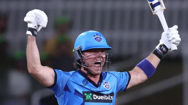 Dewald Brevis celebrates victory with his arms aloft