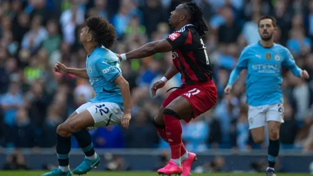 Rico Lewis of Manchester City is challenged by Adama Traore of Fulham