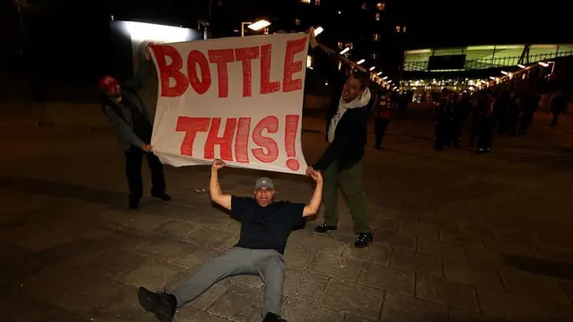 Arsenal fans hold a flag that reads 'bottle this'