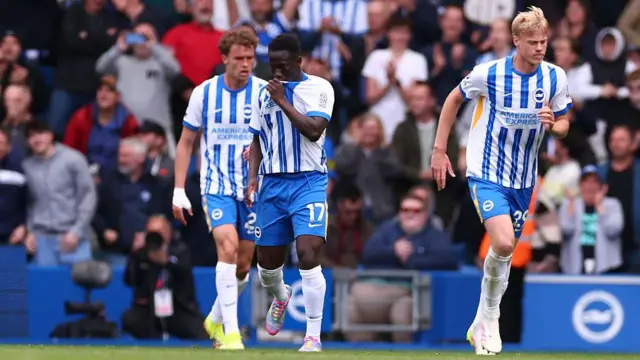 Yankuba Minteh kisses the Brighton badge after scoring 