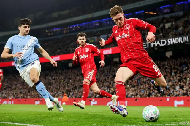 Elliot Anderson poised to cross the ball at Etihad Stadium during the game between Manchester City and Nottingham Forest